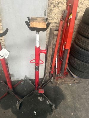 two red jacks that are sitting next to a pile of tires