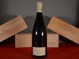 a bottle of wine sitting on a table next to two wooden boxes