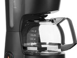 une cafetière noire posée sur un plan de travail blanc