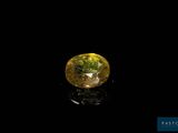 a close up of a yellow diamond on a black surface