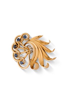 un gros plan sur une broche en or sertie de pierres bleues