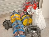 de nombreux types de tuyaux posés par terre à côté d'une porte de garage