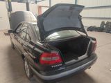 une photo d'une voiture dont le coffre est ouvert, dans un garage