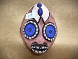 a rock with a face painted on it sitting on a table