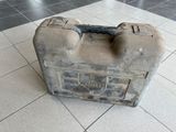 une valise sale posée par terre dans une pièce