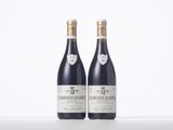 two bottles of wine sitting on top of a white table
