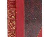 un vieux livre à la couverture rouge posé sur une surface blanche