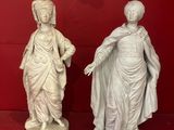 two statues of a woman and a man on a red surface