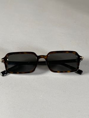 des lunettes de soleil posées sur une surface blanche, avec un fond blanc