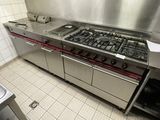 a large stainless steel kitchen with a stove and a sink
