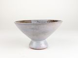 a silver bowl sitting on top of a white table