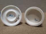 two white cups with blue designs on them on a table