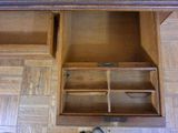 a wooden cabinet with a drawer and a pair of shoes on the floor