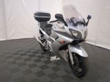 une moto argentée garée sur un sol à damier noir et blanc