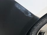 a black and white car that has a denting on it