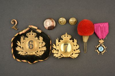 trois médailles, une médaille et un pin's posés sur une table