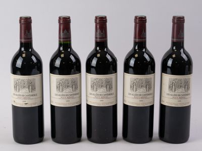 quatre bouteilles de vin sont alignées sur une surface blanche