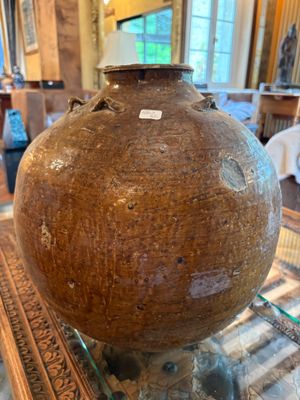 un grand vase posé sur une table en verre dans un salon
