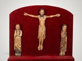 three figurines of jesus on a red stand