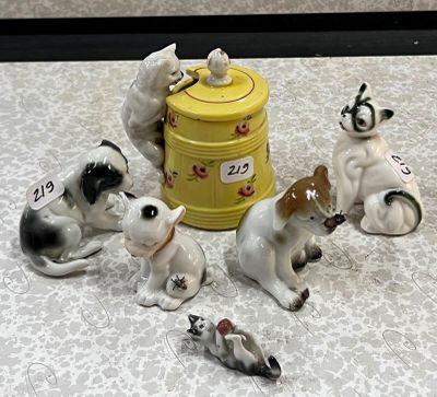 cinq figurines représentant des chiens et un chat posées sur une table