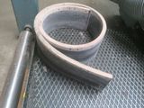 a large metal pipe on the floor next to a pipe holder