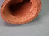 a clay vase with a hole in it on a table