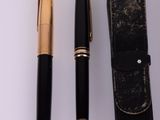 two pens and a case on a white surface