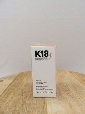 un gros plan sur un flacon de soin pour la peau K8 posé sur une table en bois