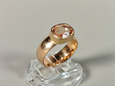 une bague en or sertie d'une pierre rose