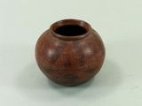 a small brown vase sitting on a white surface