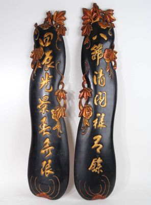 une paire de chaussures peintes en noir et or, ornées d'inscriptions en caractères asiatiques
