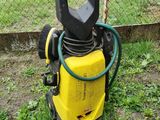a yellow and black pressurer on the ground next to a fence