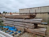 a pile of wood sitting on the ground in front of a building