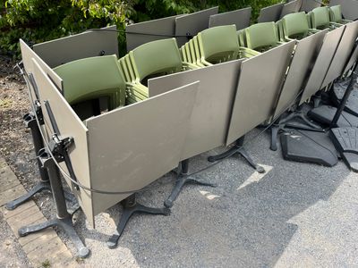 many chairs that are sitting in a row on the ground