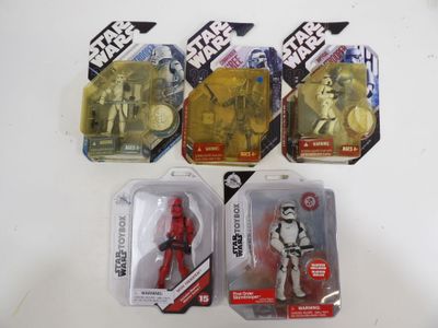 Cinq figurines de Star Wars sont exposées sur une table