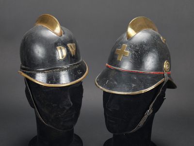 deux casques ornés de détails dorés sur les côtés, posés sur une tête de mannequin