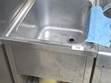 a sink in the corner of a kitchen with a trash can