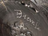 a close up of a silver vase with writing on it