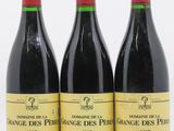 trois bouteilles de vin rouge posées l'une à côté de l'autre sur une surface blanche