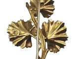 a gold leaf brooch on a white background