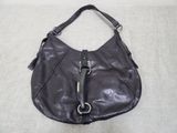 the large black purse is sitting on a white surface
