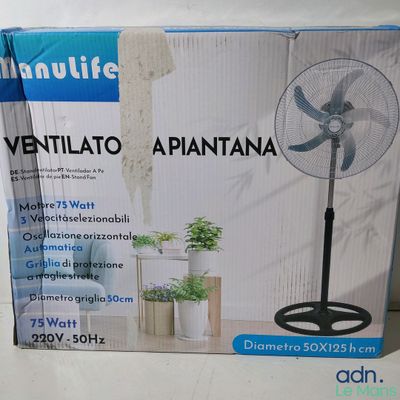 La boîte du ventilateur est posée sur la table, à côté de la plante.