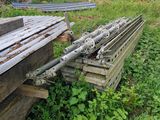 a pile of wood sitting in the grass next to a building