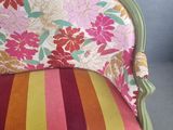 a chair that has a colorful striped cushion on it