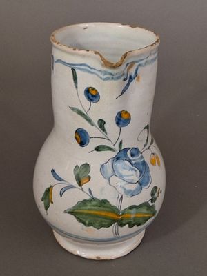 a white vase with blue and yellow flowers on it