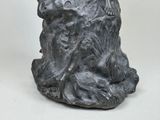 a statue of a man sitting on a tree stump