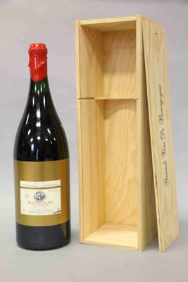 une bouteille de vin dans un coffret en bois à côté d'une bouteille de vin