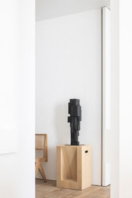 une sculpture noire posée sur une caisse en bois