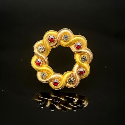 bague-broche jaune et rouge sur fond noir avec reflets
