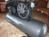 an air compressor sitting on top of a metal cart on a tiled floor